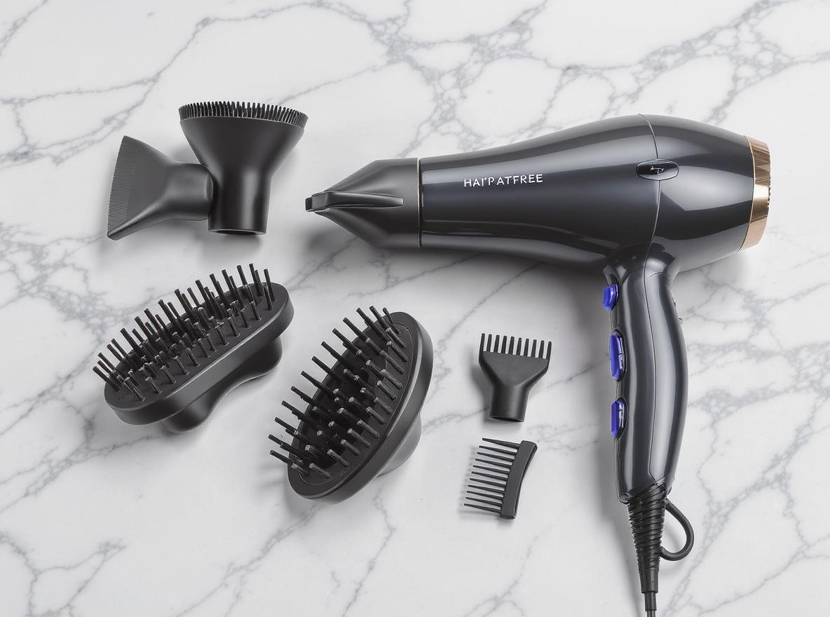 Professional hair dryer with various attachments including concentrator nozzle and diffuser on marble surface
